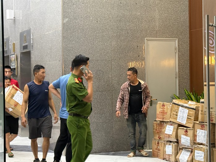 Lực lượng chức năng giám sát việc đưa các thùng carton xuống sảnh. Ảnh: Nguyễn Hưởng
