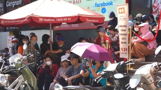 Người dân xếp hàng, ngồi chờ mua vàng trước cửa hàng Bảo Tín Minh Châu, 139 Cầu Giấy, sáng 17/10. Ảnh: Hoàng Giang
